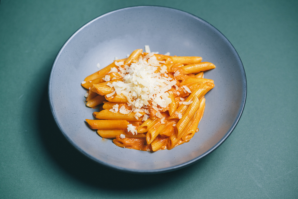 Plato de penne con salsa y parmesano