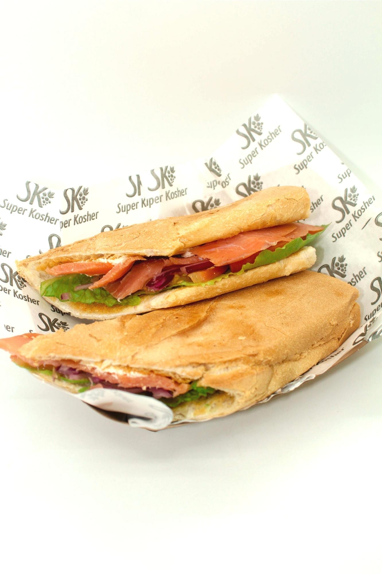 Sándwich caliente del menú lácteo de El Café servido en papel de Super Kosher