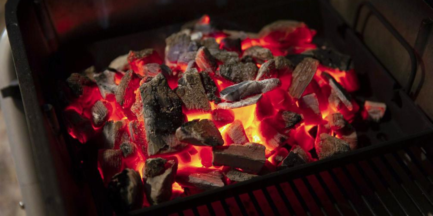 Brasas encendidas en una parrilla de carbón