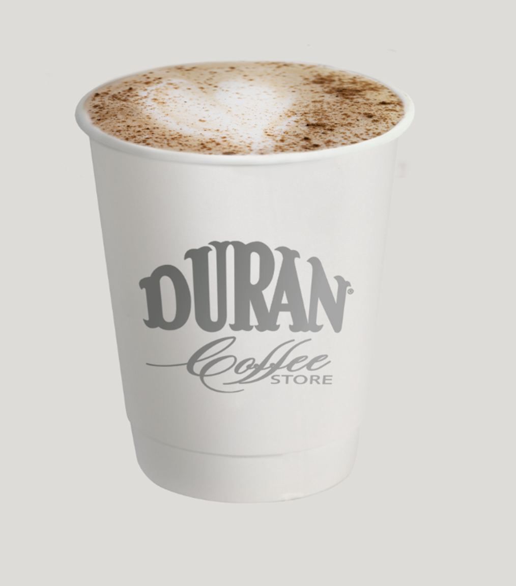 Cappuccino con espuma espolvoreada en vaso Durán Coffee Store