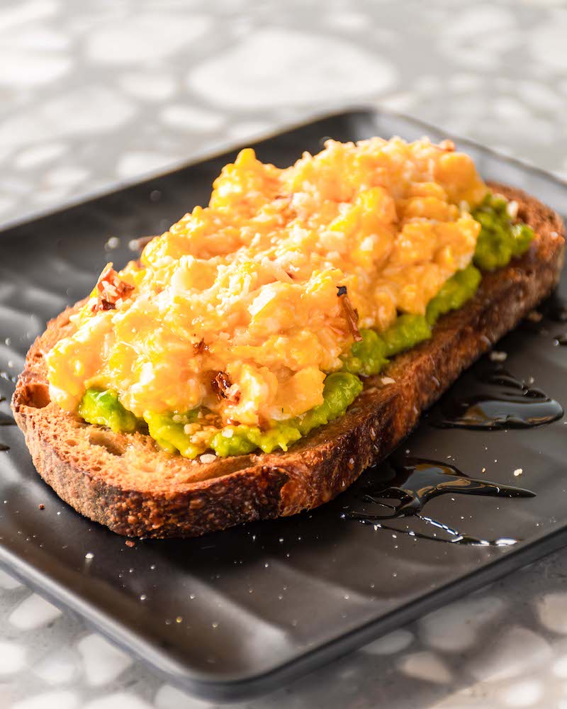 Tostada de pan de masa madre con aguacate y huevos revueltos