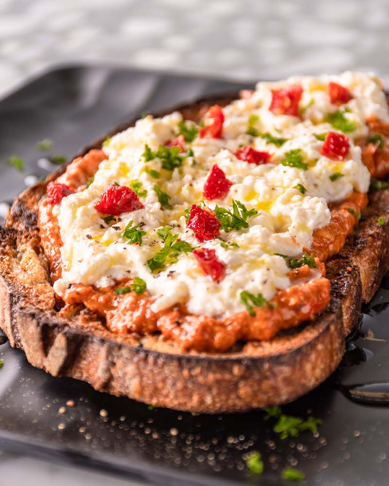 Tostada con salsa de tomate, queso fresco cremoso y pimientos