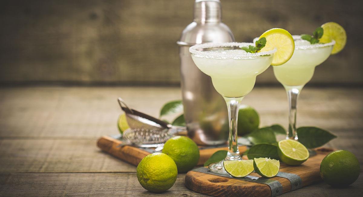 Margaritas con limón y escarchado de sal sobre tabla de madera