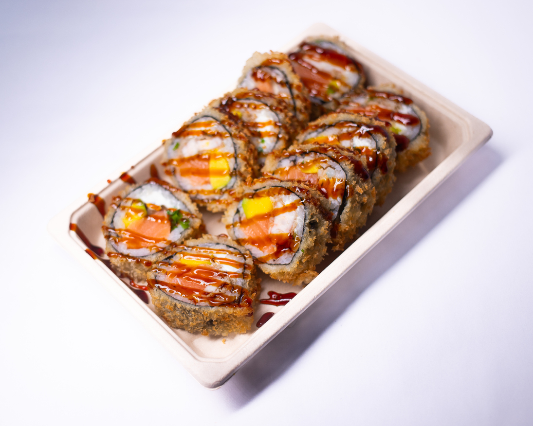 Birria roll de Quexopa Roll empanizado con salsas en bandeja