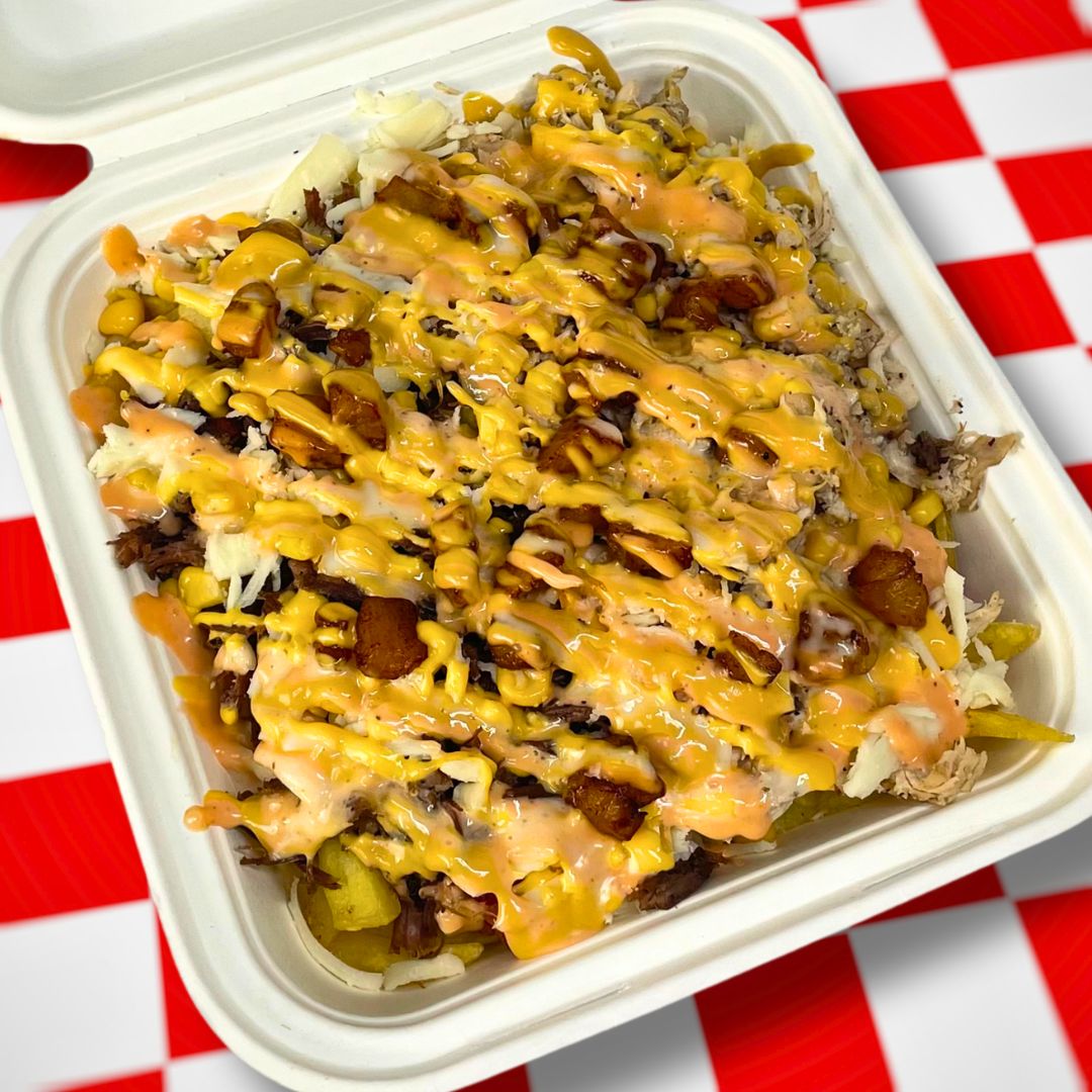 Salchipapa cargada con queso y salsas