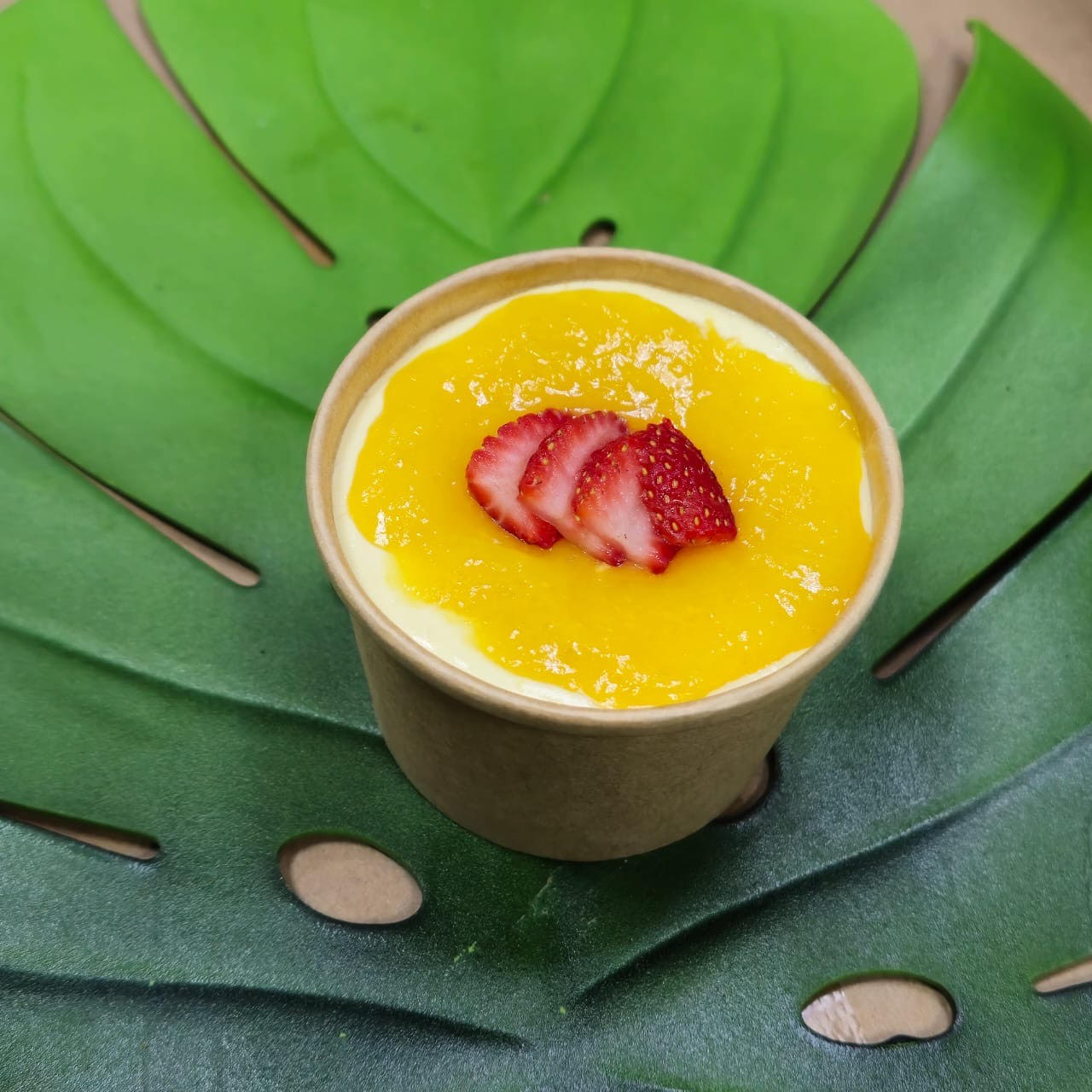 Postre cremoso de fruta amarilla con fresas en vaso