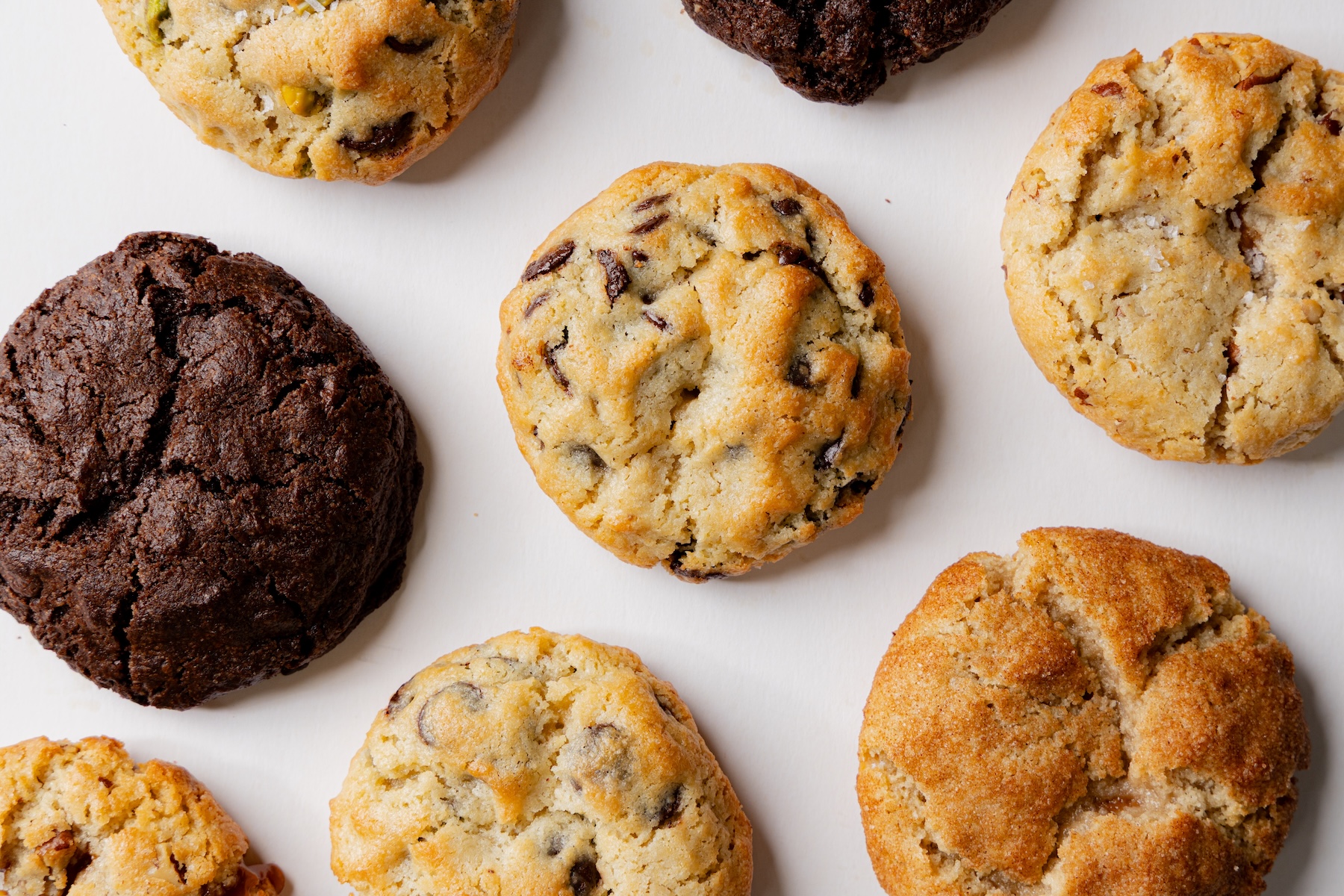 Cookies de chocolate chip, pistacho y brownie recién horneadas sobre la mesa