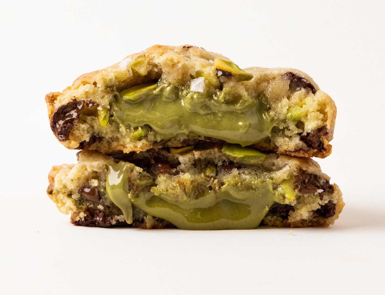 Cookie de pistacho partida con relleno verde de crema de pistacho