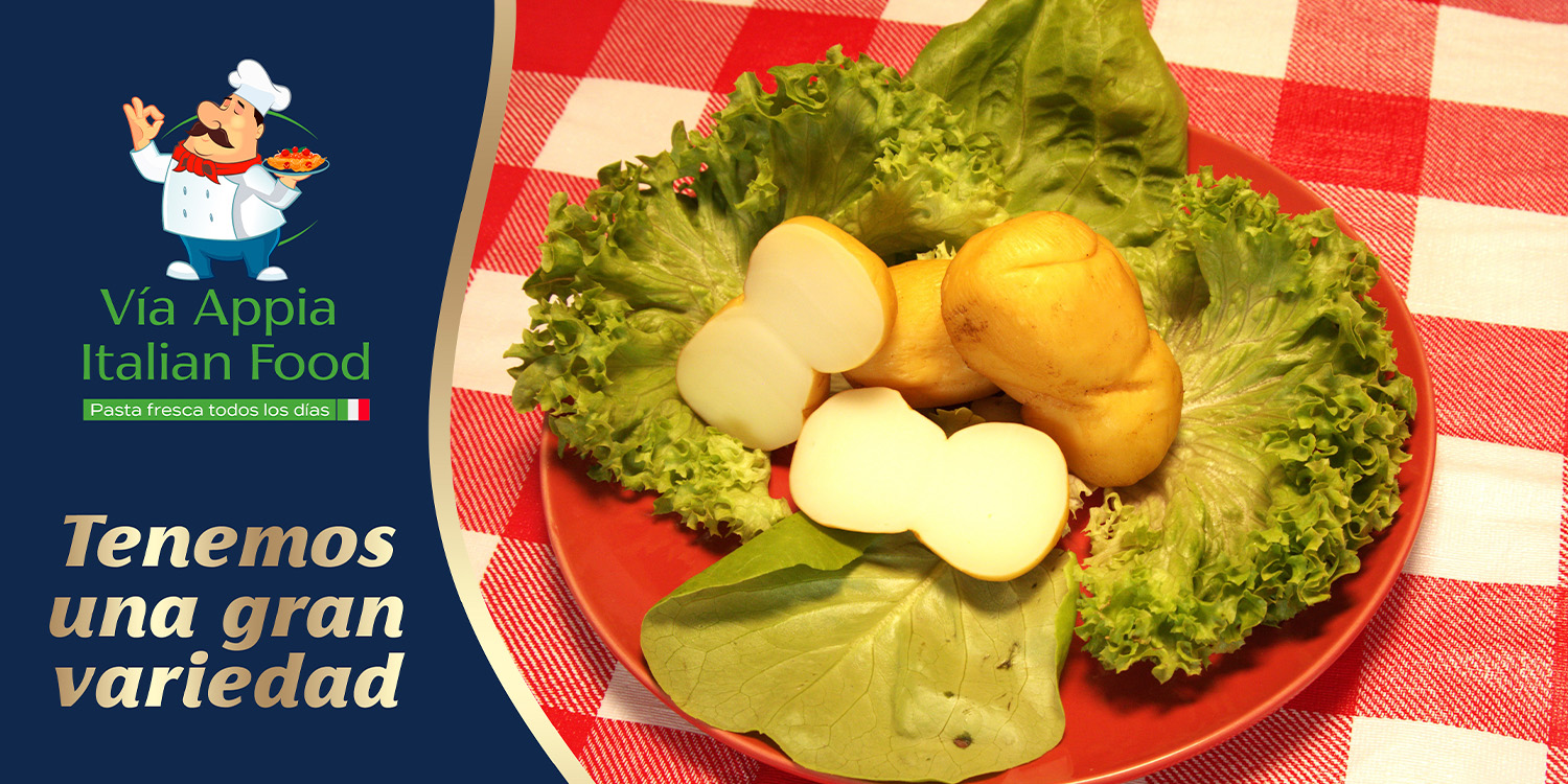 Quesos frescos y ahumados sobre hojas de lechuga en plato rojo