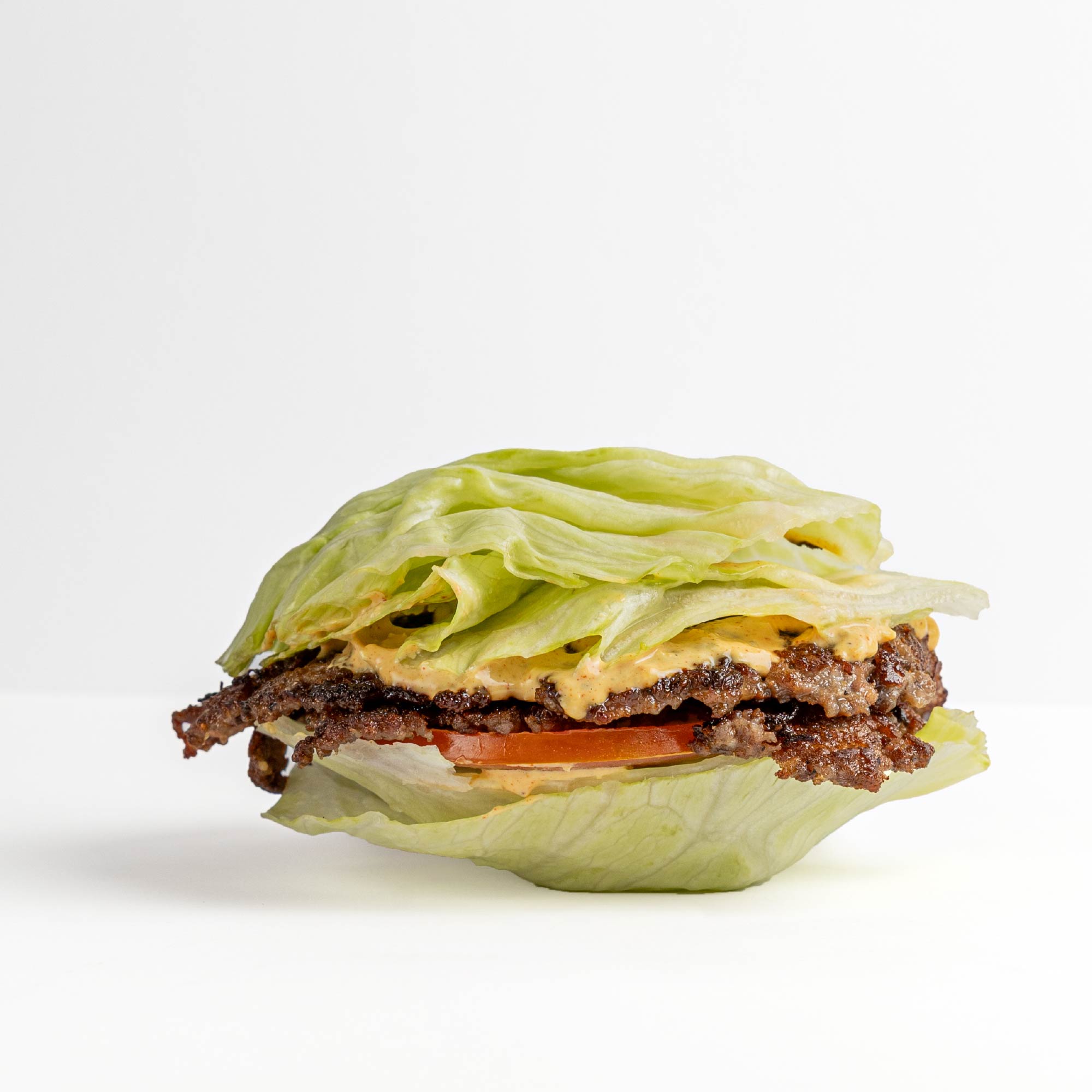Hamburguesa FudLab servida en hojas de lechuga crujiente en lugar de pan