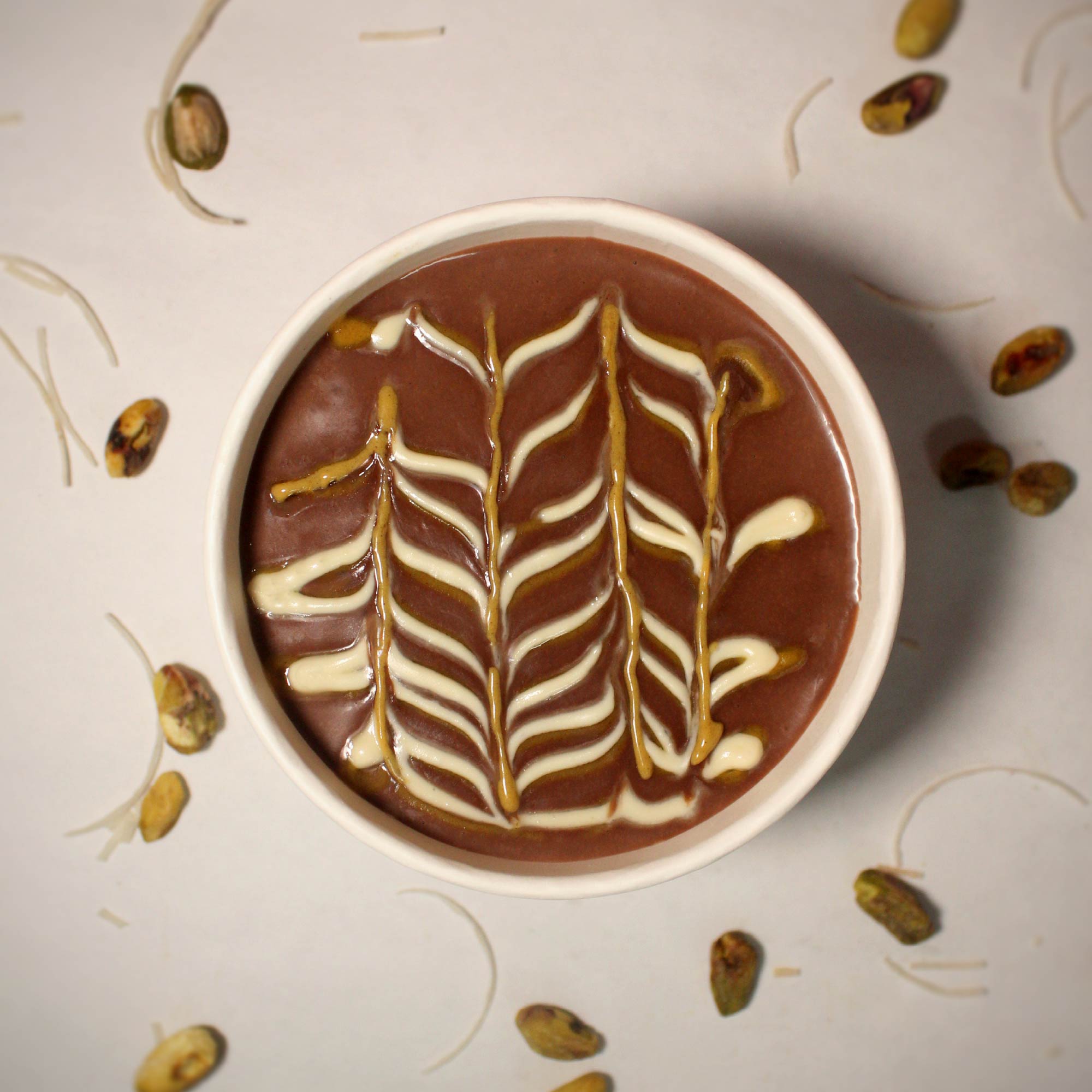Postre de chocolate FudLab decorado con líneas de crema, visto desde arriba