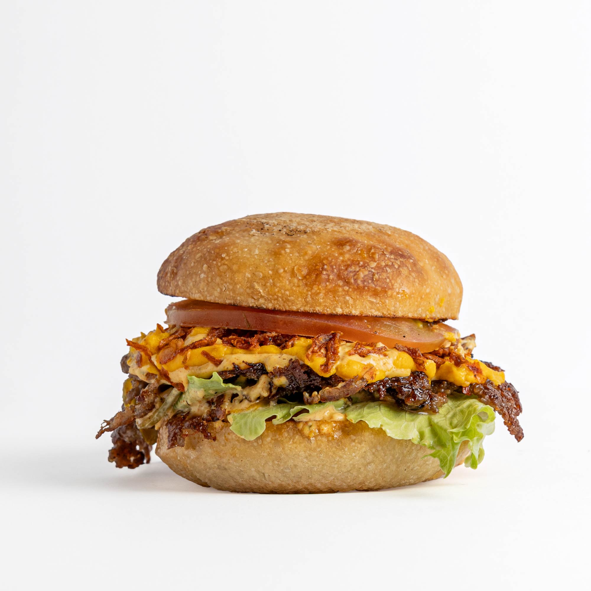 Hamburguesa FudLab con queso derretido en pan de masa madre