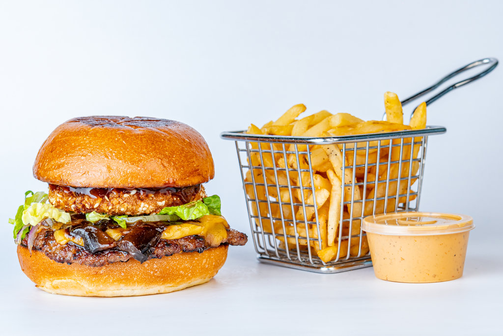Burger con queso, cebolla caramelizada y canasta de papas