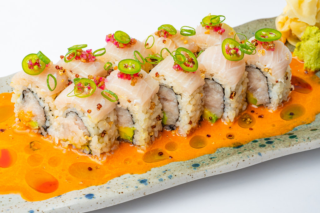 Roll de pescado blanco con jalapeño sobre salsa naranja